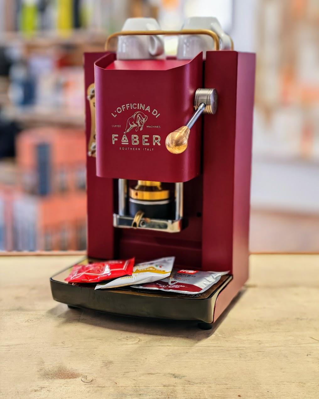 Rote Faber Kaffeemaschine mit Kaffeepads auf Holztisch, modernes Küchengerät
