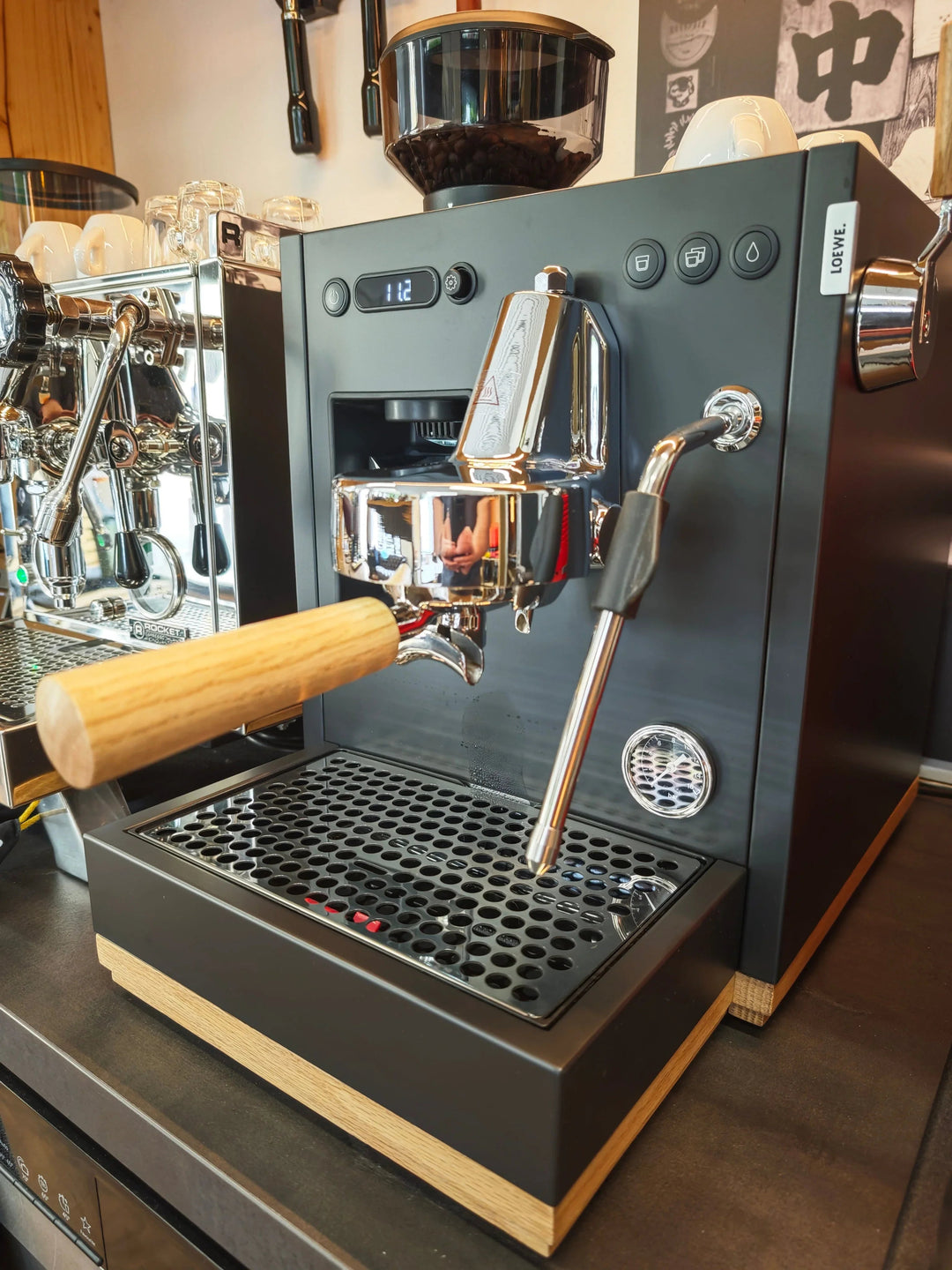 Moderne Siebträgermaschine mit Bohnenbehälter und Holzgriffen auf Kaffeetheke