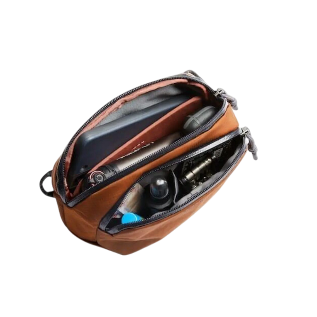 Braune Bellroy Venture Pouch Organizer mit Fächern und diversen Utensilien sichtbar