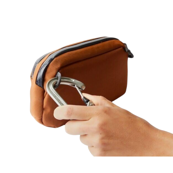 Braune Bellroy Organizer-Tasche mit Karabiner und Hand im Vordergrund